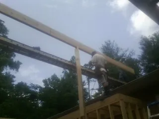 Carpenter setting a ridge beam over a new addition frame — Ice Dam Removal by Roofing Brothers in Eastanollee