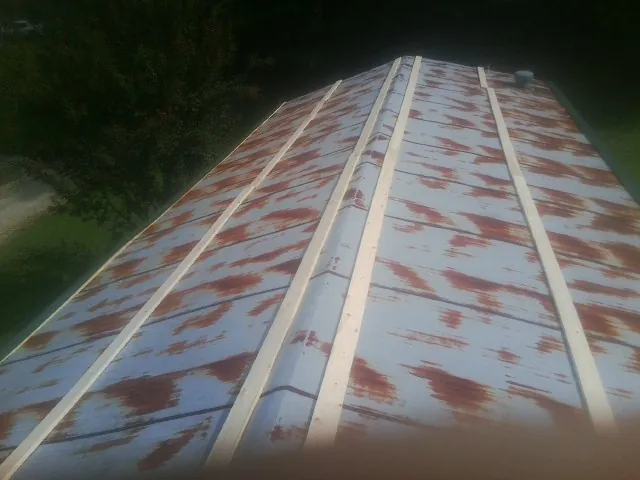 Rusted metal roof panels with new wood purlins before replacement — Storm Damage Roof Repair in Eastanollee by Roofing Brothers