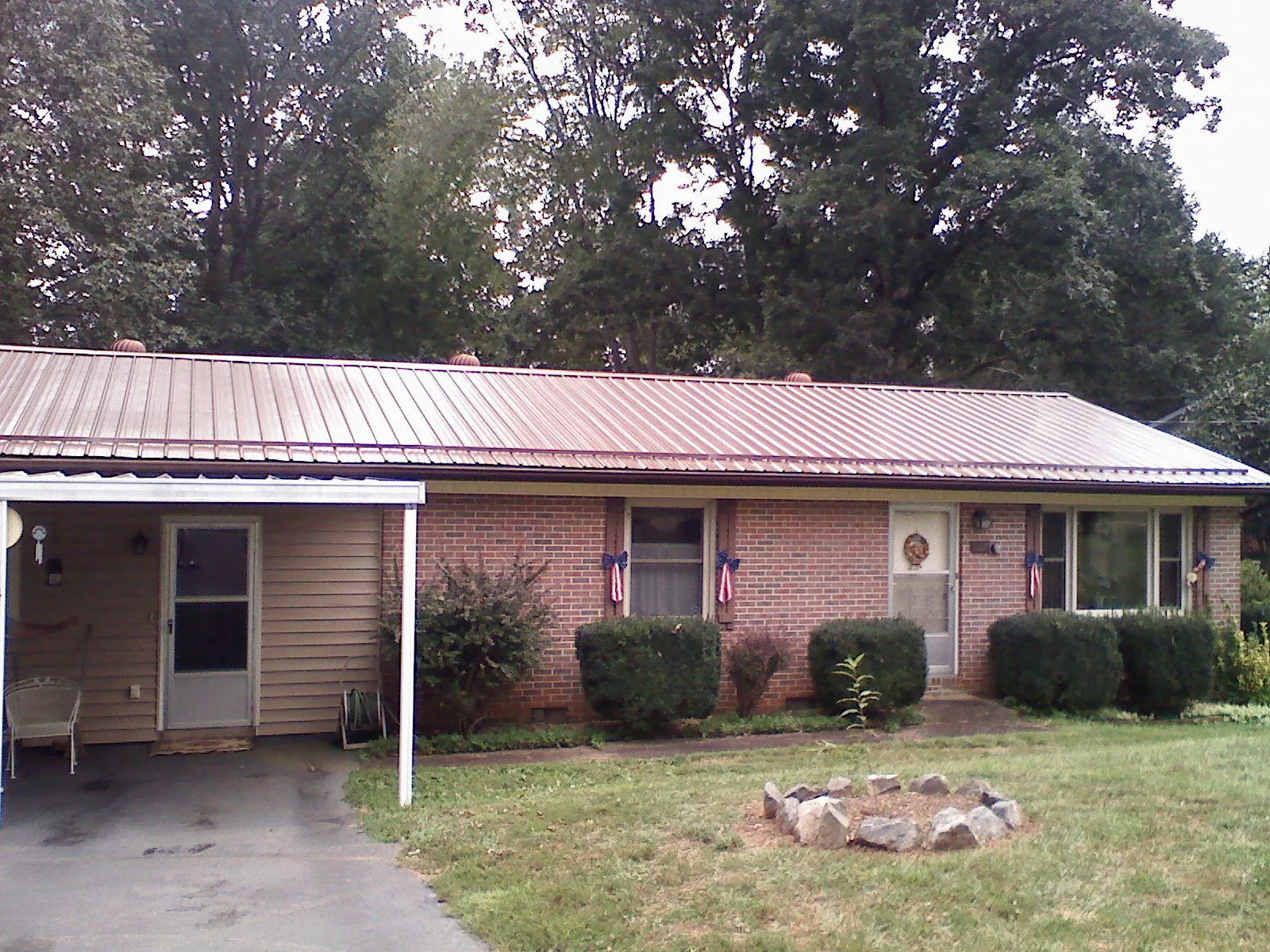 Bronze metal roof and carport on a brick ranch home — Roof Repair work by our crew in Eastanollee